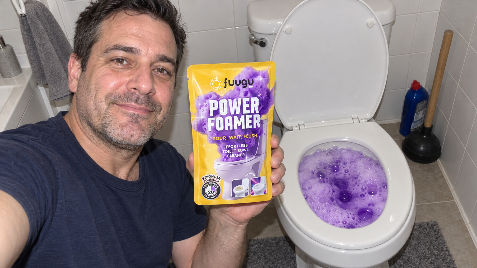 Man taking a selfie holding a Fuugu pouch beside his toilet filled with purple foam, with a plunger and drain cleaner in the corner